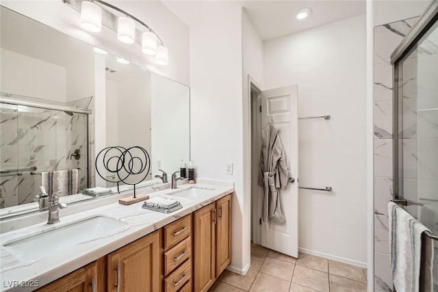 full bathroom with tile patterned floors, double vanity, a marble finish shower, and a sink