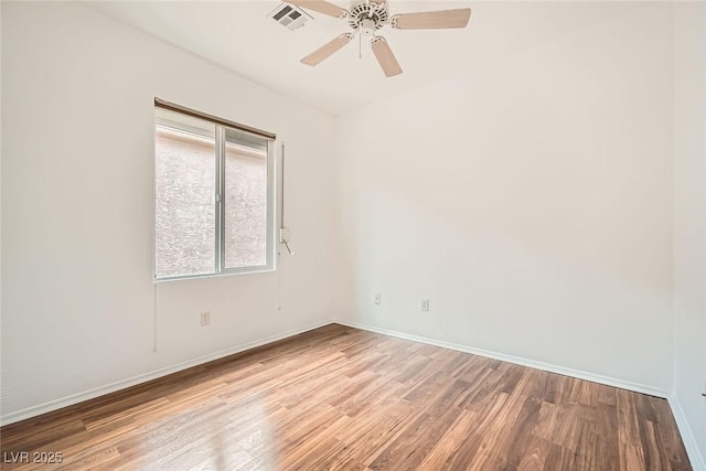 unfurnished room featuring visible vents, baseboards, wood finished floors, and a ceiling fan