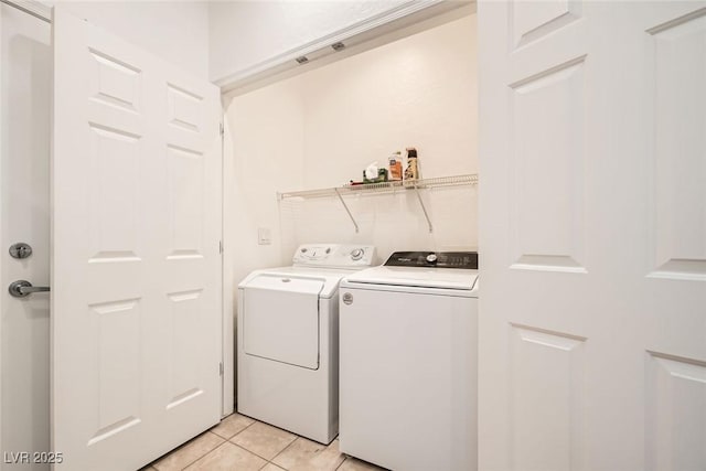 washroom with laundry area, light tile patterned floors, and washing machine and dryer