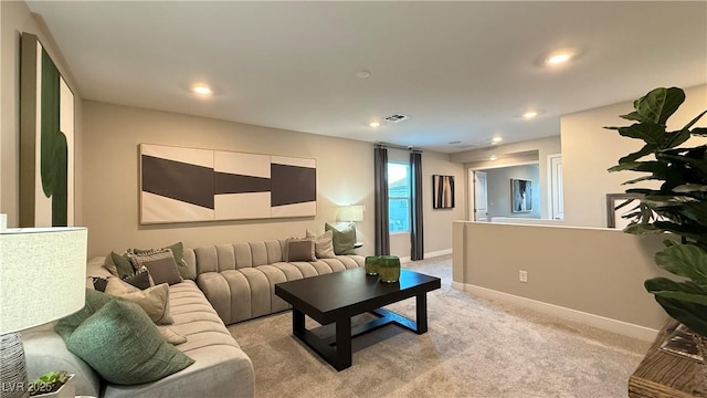 living area with recessed lighting, light colored carpet, visible vents, and baseboards