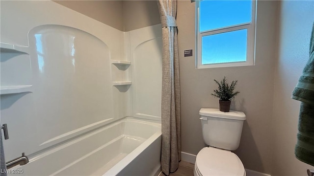 full bath with toilet, shower / bath combo, and baseboards