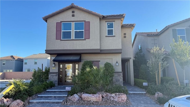 view of front of home featuring stone siding, a tiled roof, and stucco siding