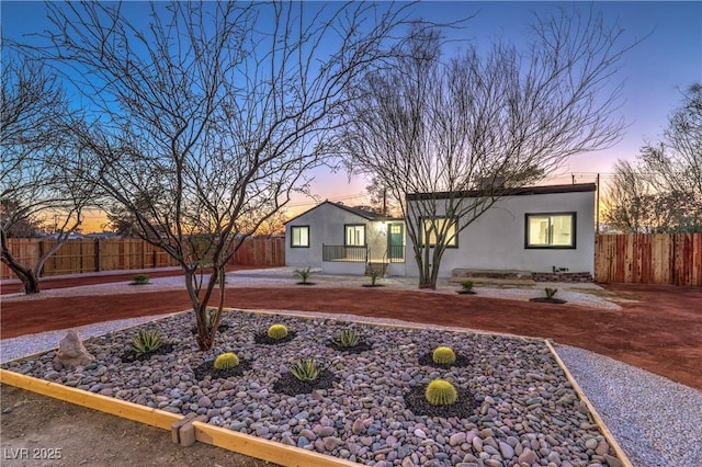 view of front of home featuring stucco siding and fence