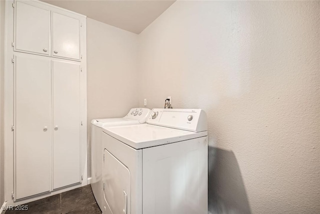 washroom featuring cabinet space and washer and clothes dryer