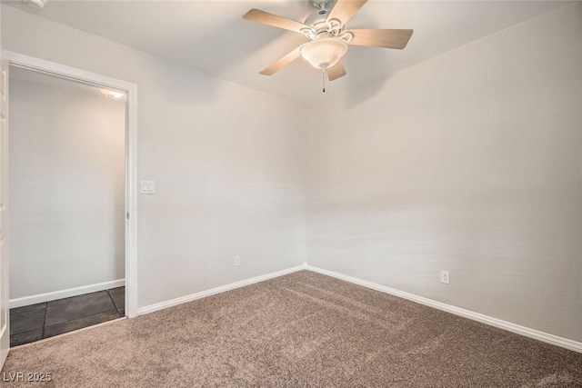 carpeted spare room with a ceiling fan and baseboards