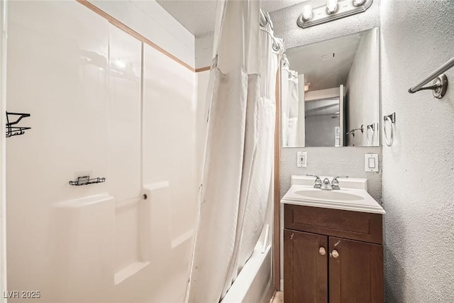 bathroom with a textured ceiling, a textured wall, shower / bath combo, and vanity