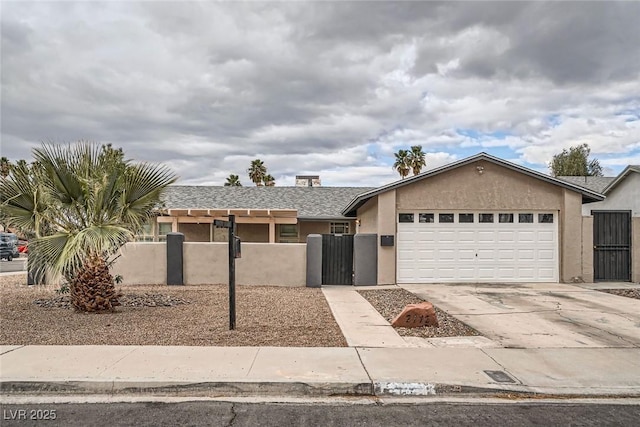 view of front of property with driveway, an attached garage, fence, and stucco siding