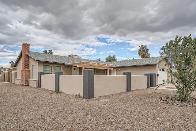 view of front of property with an attached garage, a fenced front yard, roof with shingles, and stucco siding