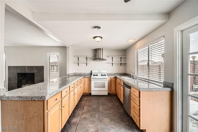 kitchen with white gas stove, wall chimney range hood, light brown cabinetry, dishwasher, and open shelves