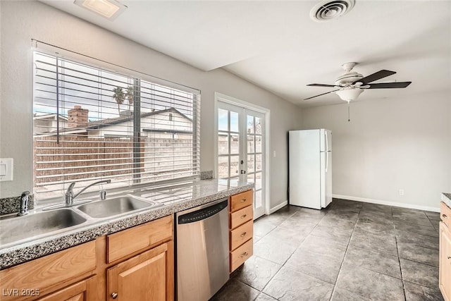 kitchen with dishwasher, visible vents, a sink, and freestanding refrigerator