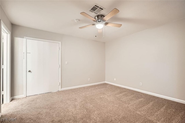 carpeted empty room with a ceiling fan, visible vents, and baseboards