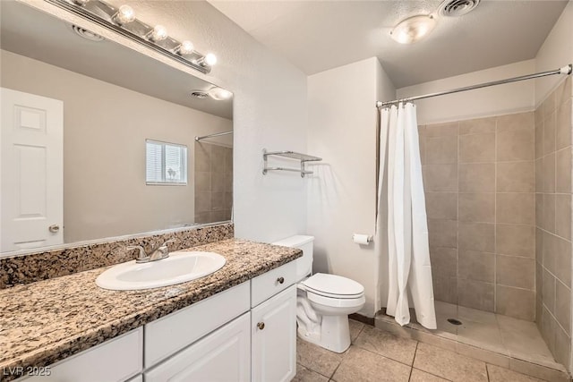 bathroom with toilet, vanity, a tile shower, and visible vents