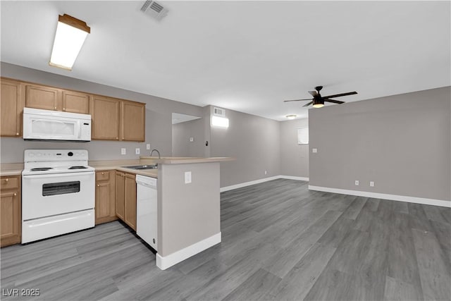 kitchen featuring a peninsula, white appliances, baseboards, light countertops, and light wood-type flooring