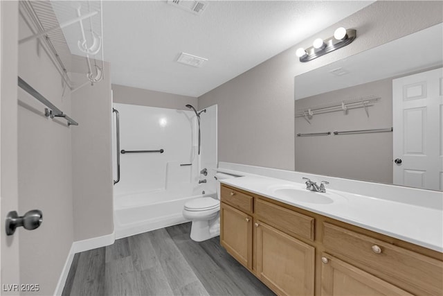 full bath with shower / tub combination, toilet, wood finished floors, visible vents, and vanity