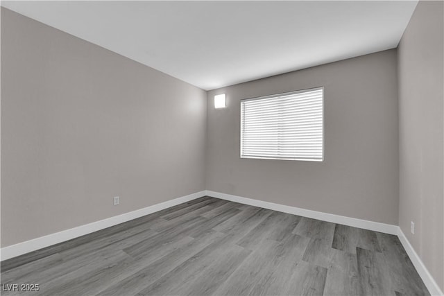 empty room with wood finished floors and baseboards