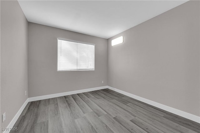 unfurnished room featuring baseboards and wood finished floors