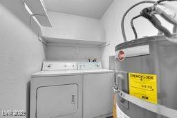 washroom featuring washing machine and dryer, laundry area, and electric water heater