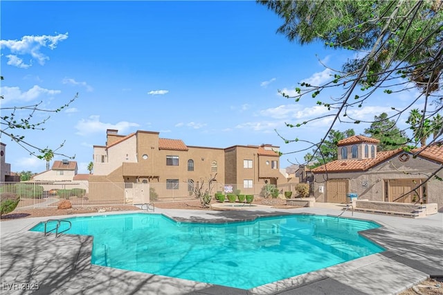 community pool with a residential view, fence, and a patio