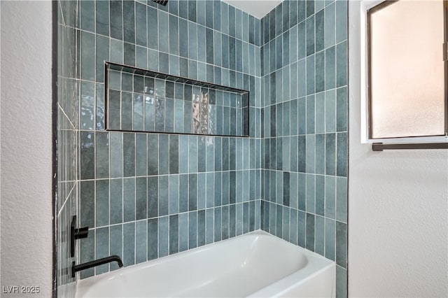 bathroom featuring shower / bathing tub combination and a textured wall