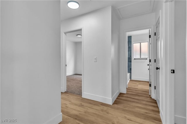 hall featuring light wood-style floors and baseboards