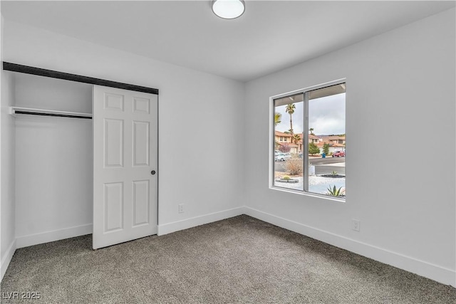 unfurnished bedroom featuring a closet, baseboards, and carpet flooring