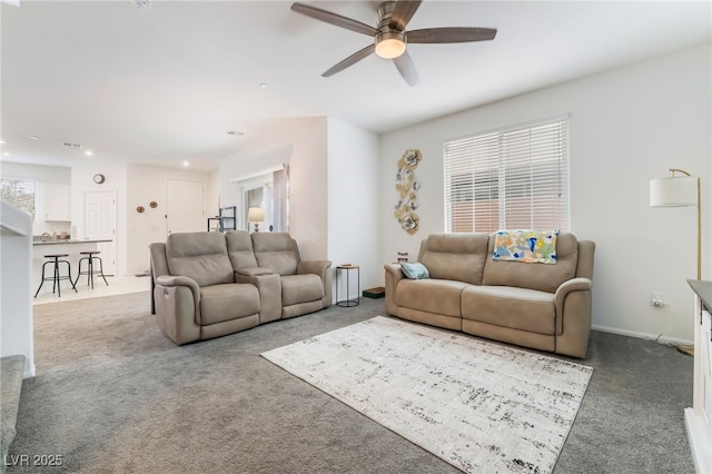 carpeted living room featuring a ceiling fan and baseboards