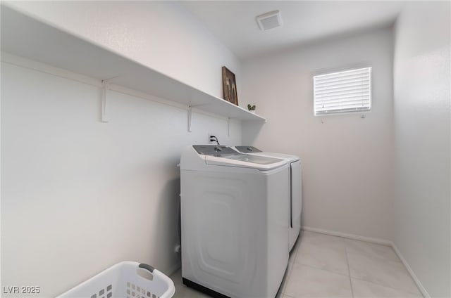 washroom with light tile patterned floors, laundry area, visible vents, baseboards, and washing machine and clothes dryer