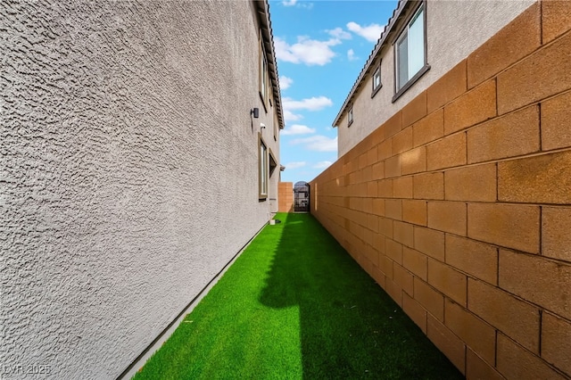 view of home's exterior featuring a lawn, a fenced backyard, and stucco siding