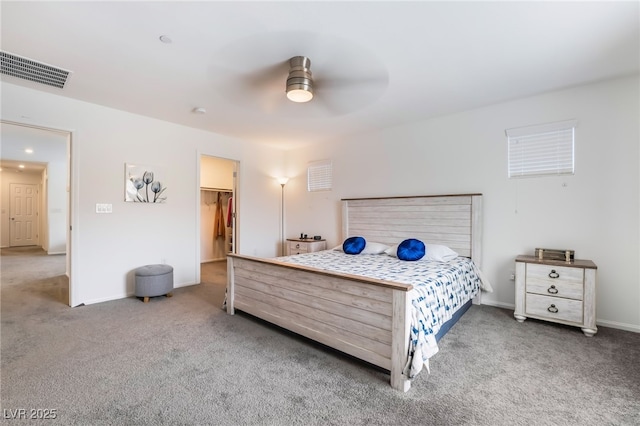 bedroom featuring carpet floors, ceiling fan, a spacious closet, and visible vents