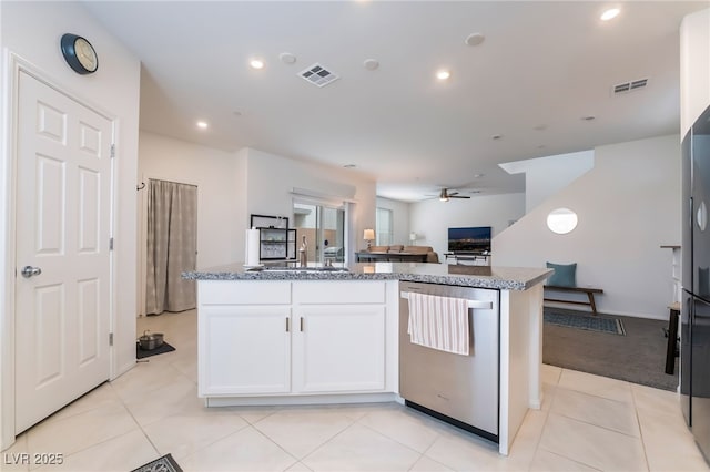 kitchen with a center island, visible vents, open floor plan, white cabinetry, and dishwasher