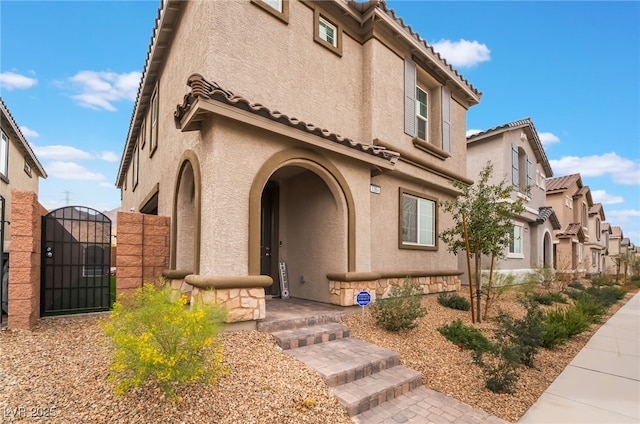 exterior space featuring a gate, a tiled roof, and stucco siding