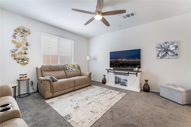 living room with baseboards, carpet flooring, visible vents, and a ceiling fan