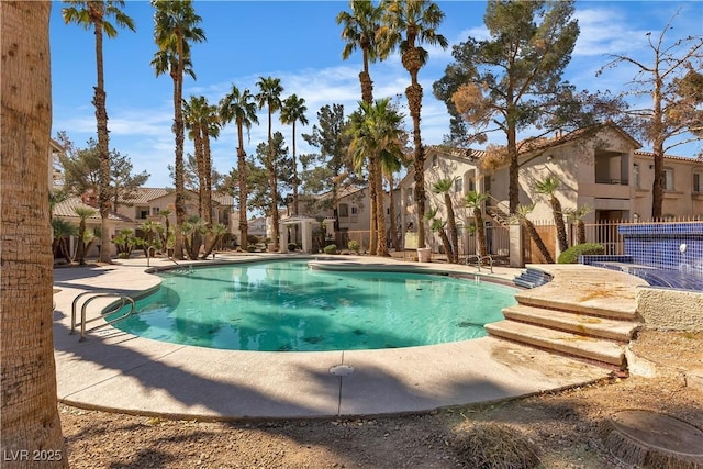 pool featuring a patio, fence, and a residential view