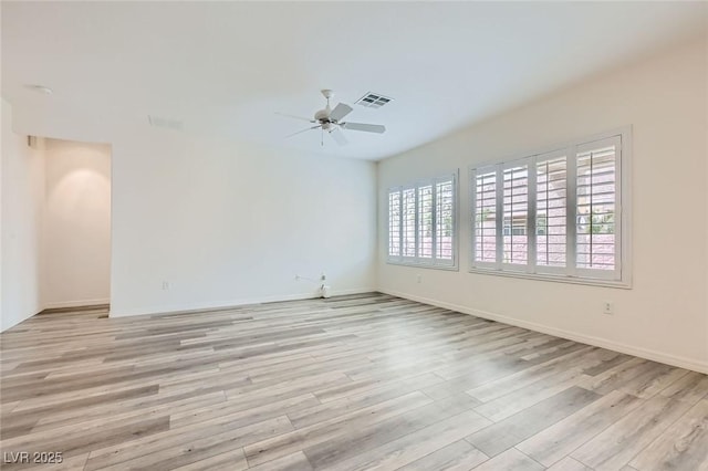 spare room featuring a ceiling fan, baseboards, visible vents, and light wood finished floors