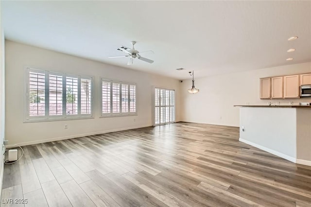 unfurnished living room with ceiling fan, recessed lighting, light wood-style flooring, and baseboards