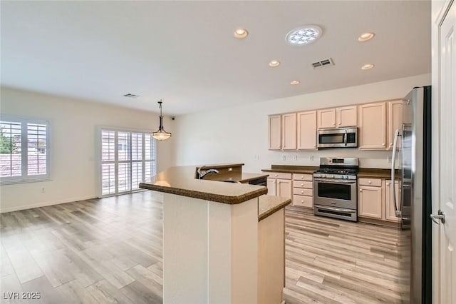 kitchen with recessed lighting, stainless steel appliances, visible vents, light wood-style floors, and dark countertops