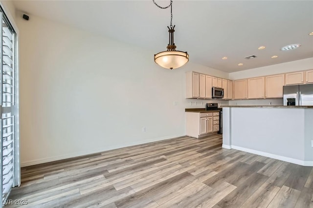 kitchen with visible vents, baseboards, light wood-style flooring, appliances with stainless steel finishes, and hanging light fixtures