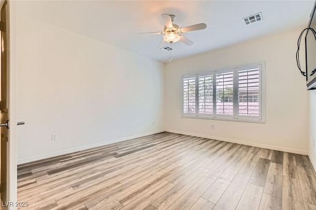 unfurnished room with a ceiling fan, visible vents, light wood-style flooring, and baseboards