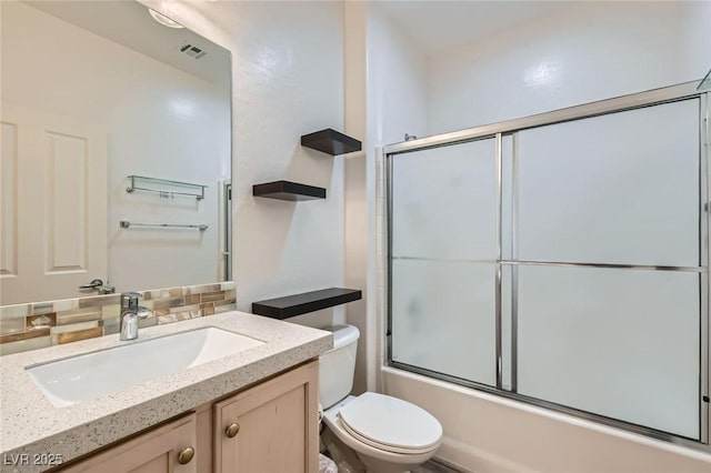 full bath with toilet, shower / bath combination with glass door, visible vents, vanity, and tasteful backsplash