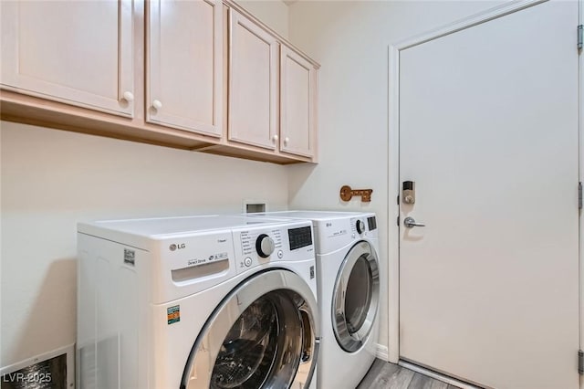 laundry area featuring light wood-style floors, washing machine and dryer, and cabinet space