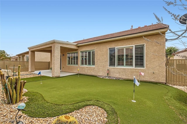 rear view of house featuring fence, a patio, and stucco siding