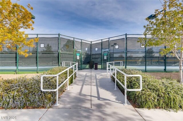 view of community with a tennis court and fence