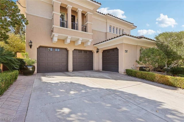 exterior space featuring concrete driveway, a balcony, an attached garage, and stucco siding