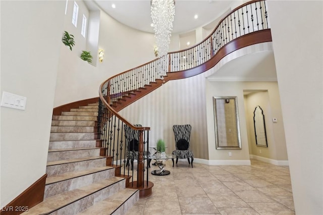 staircase with recessed lighting, baseboards, a notable chandelier, and a high ceiling