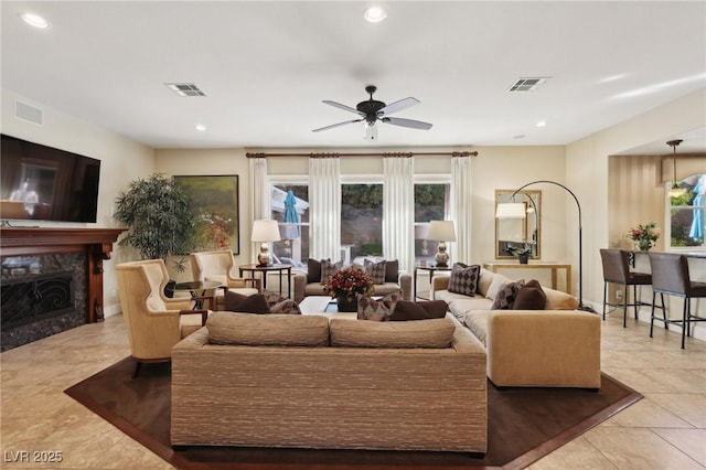 tiled living area with a high end fireplace, visible vents, ceiling fan, and recessed lighting