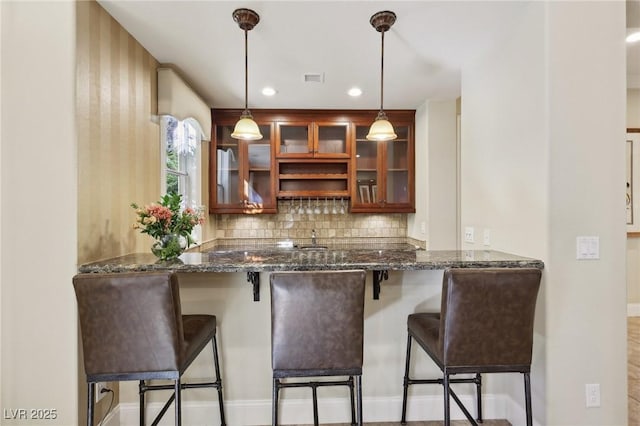 bar featuring recessed lighting, a sink, visible vents, hanging light fixtures, and decorative backsplash