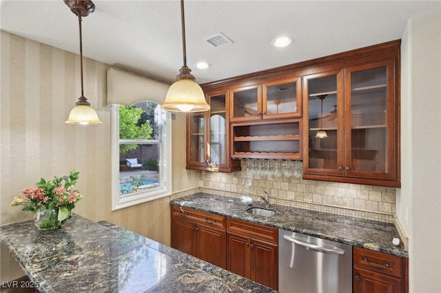 kitchen with decorative light fixtures, visible vents, backsplash, stainless steel dishwasher, and a sink