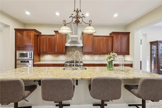 kitchen featuring appliances with stainless steel finishes, backsplash, a sink, and a large island with sink