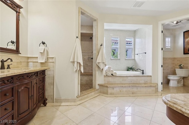 3863 Glasgow Green Dr, Las Vegas, NV 89141 - bathroom featuring a stall shower, tile walls, visible vents, a garden tub, and vanity