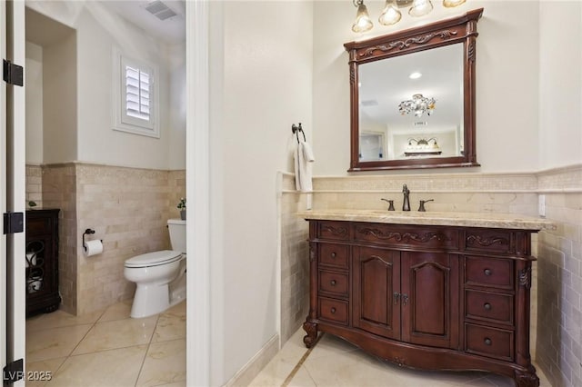 bathroom featuring tile patterned flooring, visible vents, and tile walls